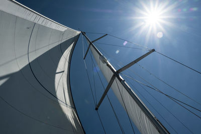 Low angle view of sailboat against blue sky