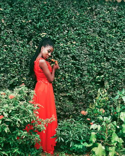 Woman standing by plants on field