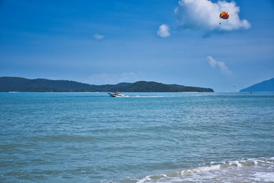 Parasailing on the waves of the azure andaman sea under the blue sky near the shores of cenang beach