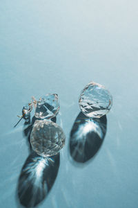 Three crystals with light refraction on blue minimal background