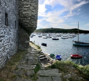 Boats moored in sea against mountain and sky