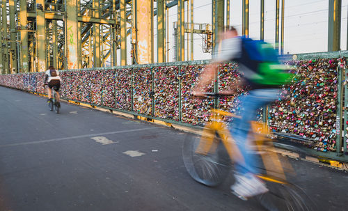 Blurred motion of people riding bicycle in city