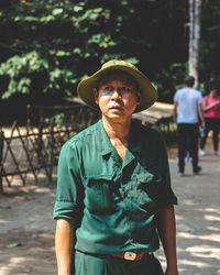 Full length of man wearing hat standing against blurred background