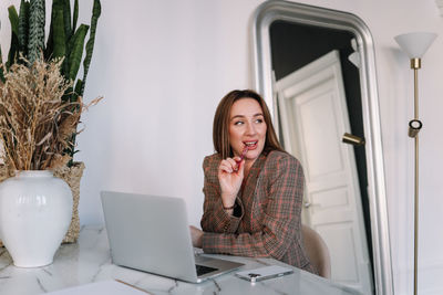 A business woman works online using a laptop phone and technology while sitting in the office