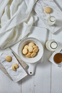 Directly above shot of cookies by milk in bottle on table