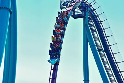 Low angle view of amusement park ride against blue sky