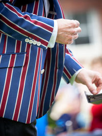 Midsection of man wearing striped blue and red jacket