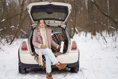 Woman sitting in trunk of mini cooper