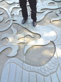 Low section of man standing on tiled floor