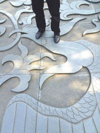 Low section of man standing on tiled floor