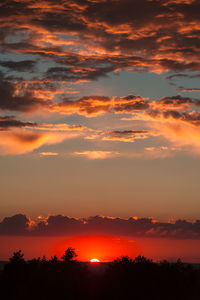 Scenic view of silhouette landscape against orange sky