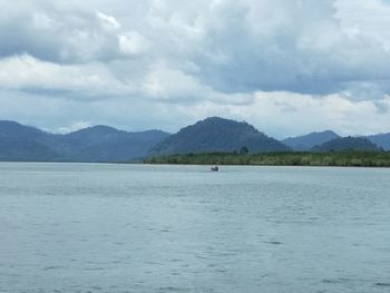 Scenic view of sea and mountains against sky