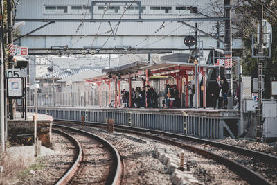 People at railroad station platform in city