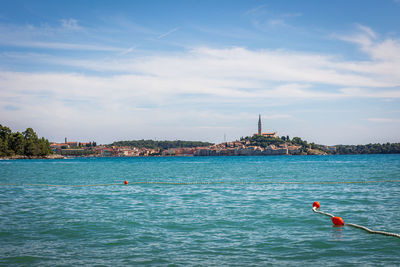 Rear view of woman swimming in sea against sky