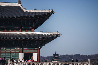 Group of people in front of building against clear sky