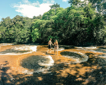 People standing on land against trees