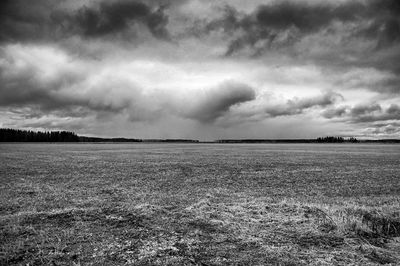 Scenic view of field against cloudy sky