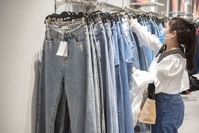 Woman wearing mask looking at garments at store