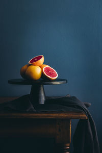 Fruits on table against orange background