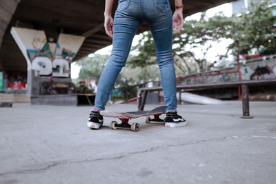 Low section of man skateboarding on street