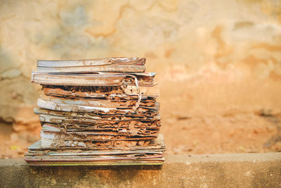 Close-up of old stack on table against wall