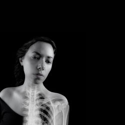 Digital composite image of woman looking down against black background