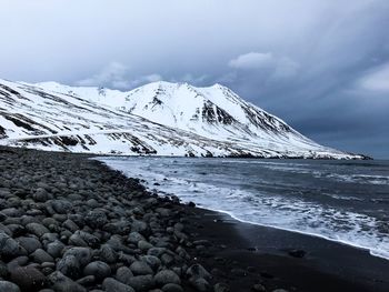 Scenic view of sea and snowcapped mountain against sky