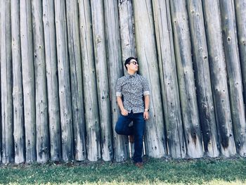 Portrait of man standing on tree trunk