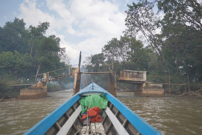 Boats moored in swimming pool by lake against sky