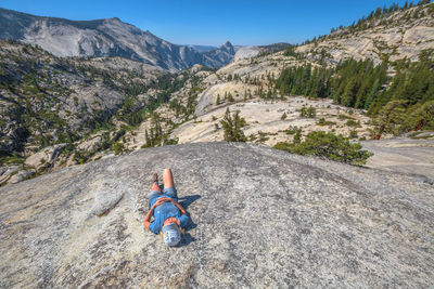 Rear view of man on rock in mountains