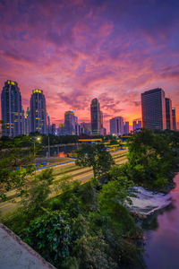 Buildings in city against sky during sunset