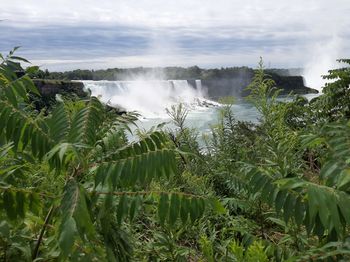 Scenic view of waterfall against sky