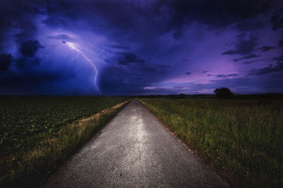 Scenic view of road on field against sky