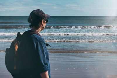 Woman standing on beach against sea