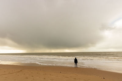 Man standing on beach against sky