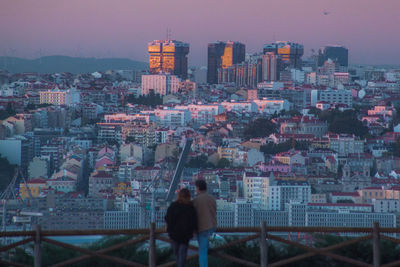 Buildings in city against sky at dusk