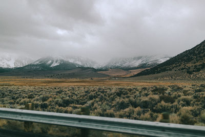 Scenic view of road by mountains against sky