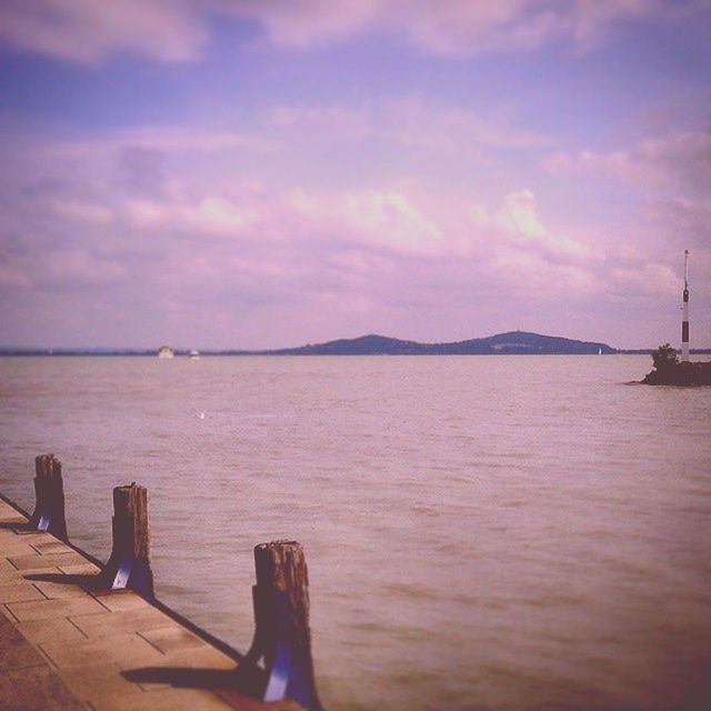 water, sky, sea, tranquil scene, tranquility, pier, cloud - sky, scenics, beauty in nature, rippled, nature, one person, cloud, nautical vessel, lake, idyllic, outdoors, wood - material, boat, jetty