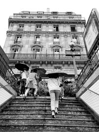 Low angle view of people walking on staircase of building