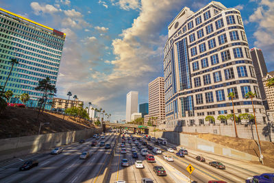 Traffic on city street amidst buildings against sky