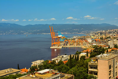 High angle view of cranes and buildings in city