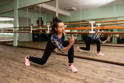 Full length of young woman sitting on floor