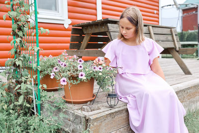 Portrait of smiling young woman standing amidst plants