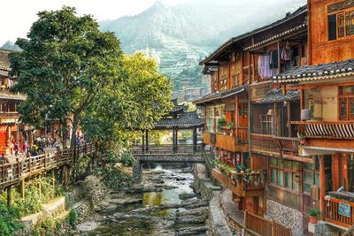 Houses by river and buildings in city