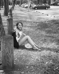 Portrait of smiling young woman sitting at park