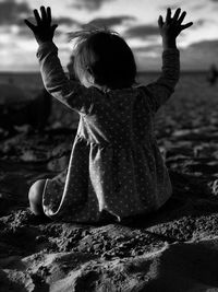 Rear view of girl with arms raised