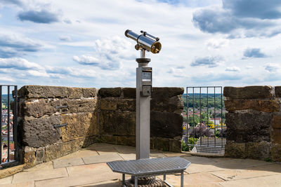Paid single lens telescope, set on a high vantage point with a view of the city.