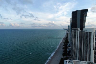 Scenic view of sea by buildings against sky