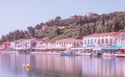 Boats moored in water against clear sky