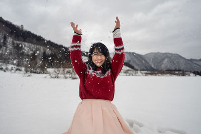 Cheerful woman standing on snow 